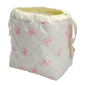 Quilted cosmetic bag with cute bow pattern, portable drawstring travel storage pouch.