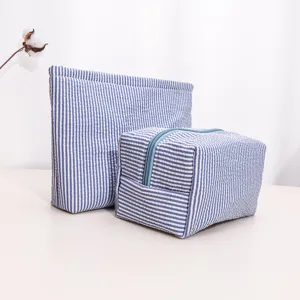 Close-up of blue white striped travel cosmetic bags set, portable and large capacity storage.