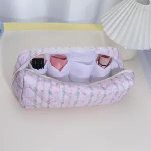 Detail view of the pink floral quilted storage bag interior compartments for hair dryer.