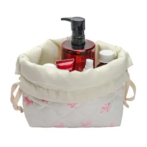 Quilted makeup bag for travel, portable cosmetic pouch with drawstring and bow print.