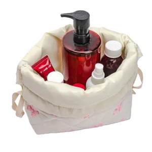Quilted cosmetic bag with drawstring for travel and makeup storage organizer pouch.