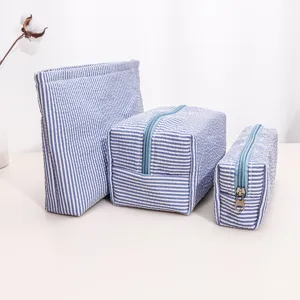 Detail view of blue and white striped cosmetic bag set, portable travel organizer pouch.