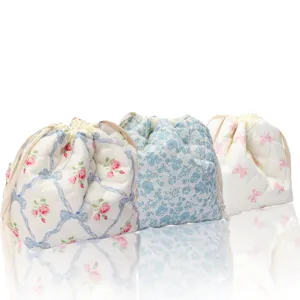 Quilted drawstring cosmetic pouch detail showing soft floral pattern and neat stitching work.