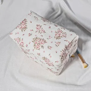 Quilted floral cosmetic bag detail view, showing vintage pattern and zipper closure structure.