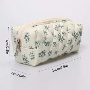Quilted floral cosmetic bag detail, soft fabric, smooth zipper, compact storage pouch.