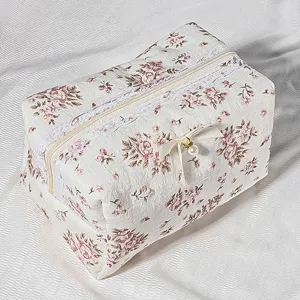 Quilted floral cosmetic bag with delicate lace trim and cute bow detail. Perfect detail shot.