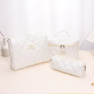 Quilted cosmetic bag set in white with small black polka dots, portable makeup pouch and case.