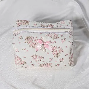 Quilted floral cosmetic bag detail showcasing lace trim, zipper, and cute bow pearl pendant.
