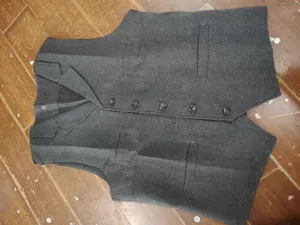Men's dark grey herringbone suit vest detail, classic lapel single breasted design.