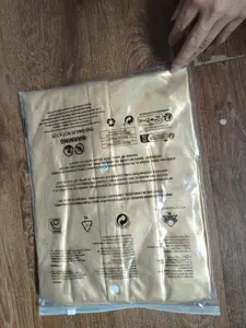 Détail emballage chemise disco dorée en sachet plastique transparent avec texte d'avertissement.