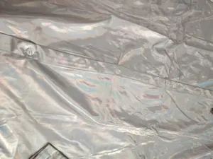 Vue détaillée en gros plan de la patte de boutonnage et des boutons de chemise holographique.
