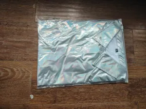 Vue de détail de la chemise disco métallique pour homme pliée dans un emballage transparent.