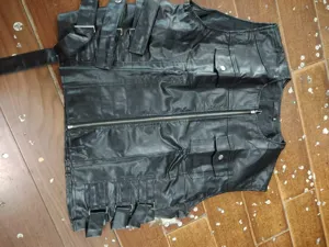 Detalle chaleco de cuero sintético para hombre, chaleco moto negro estilo punk con bolsillos.