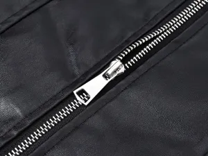 Primer plano detallado de una elegante cremallera metálica plateada en un chaleco negro.