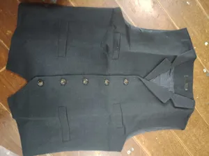Men suit vest detail showing classic lapel, front button closure, and herringbone fabric.