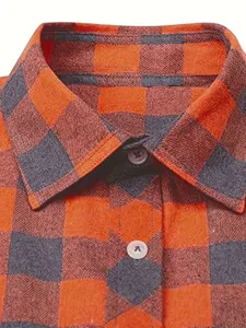 Close-up detail of men's orange and grey plaid flannel shirt collar and buttons texture.