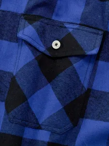 Detailed close-up view of the blue-black plaid flannel shirt chest pocket and white button.