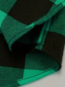 Green and black plaid flannel shirt fabric detail, soft texture and fine stitching closeup.