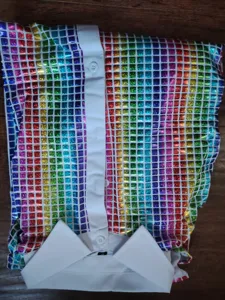 Détail chemise homme disco manches longues, haut à sequins grille colorée col blanc boutons.