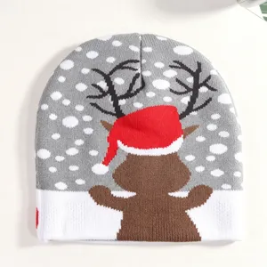 Christmas knitted beanie hat detail showing cute reindeer snow pattern and cozy winter fabric texture.