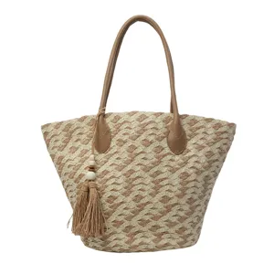 Gewebte Stroh Strand Handtasche für Damen mit Ledergriffen und Quasten Anhänger Vorderansicht.