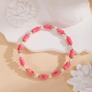 Delicato braccialetto di perline rosa con perle bianche e raffinati dettagli dorati.