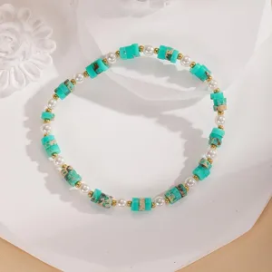 Primo piano dettagliato del braccialetto di perle turchesi in stile estivo chic.