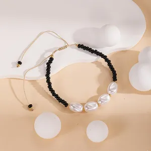 Vue principale d'un bracelet de perles d'été élégant avec des perles noires et blanches, ajustable.