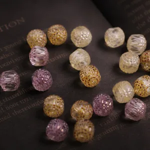 Detailed view of 10mm faceted transparent Czech glass beads in vintage yellow and purple.