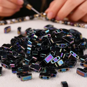 Detail shot of black iridescent two-hole beads for DIY jewelry making and craft projects.