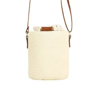 White woven bucket bag with brown leather straps and wooden bead drawstring for women beach.
