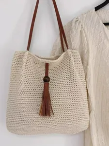 Handmade crochet tote bag with brown leather straps and stylish tassel charm for women daily use.