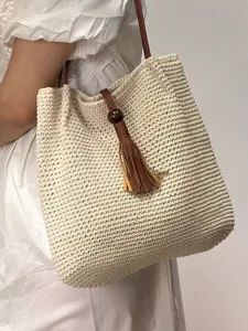 Handmade crochet straw tote bag for women, large capacity beach shoulder bag with tassel charm.