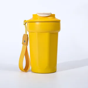 Detailansicht des gelben edelstahl achteckigen thermo kaffeebechers mit tragegurt.