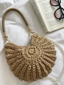 Vue détaillée du sac à main chic en crochet beige avec des perles et une poignée tressée.