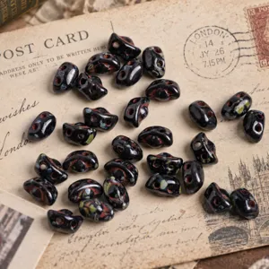 Close-up detail of black dual-hole Czech glass ingot beads, ideal for DIY jewelry crafting.