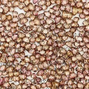 Close-up detail of T-shaped glass beads, perfect for DIY jewelry making and craft projects.