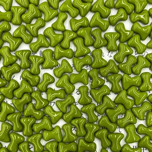 Close-up detail of Czech glass T-bone beads in green, 2x8mm size for DIY jewelry crafts.
