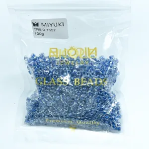 Detailed shot of 100g blue triangle glass seed beads TR5/0 in transparent packaging.