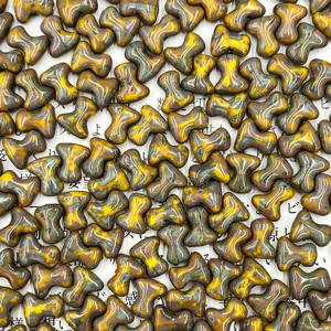 Close-up detail of T-shaped bone glass beads, vintage yellow and green glazed DIY charms.