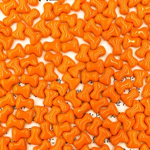 Detailed close-up shot of vibrant orange glass T-bone beads, showcasing glossy texture.