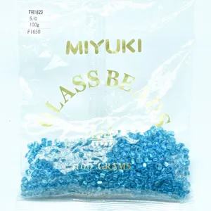 Close-up detail of blue glass beads in transparent packaging, showing size and texture clearly.