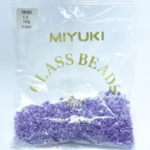 Close-up detail of purple Miyuki glass beads in a transparent package, 100g pack size.