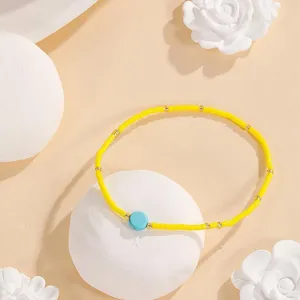 Close-up detail of yellow beaded bracelet with blue stone accent for unique daily style.