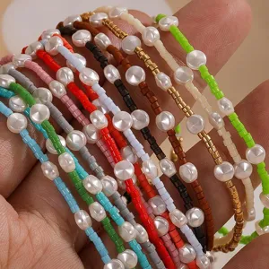 Close-up detail of colorful seed beads and coin pearl bracelets, stacked handmade jewelry.
