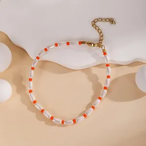 Detail view of stylish layered beaded bracelet with white pearls and orange beads adjustable.