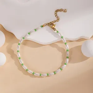 Close-up of a charming beaded bracelet with white and green elements and adjustable chain.