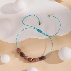Bracelet de perles fait main avec pierres roses naturelles et cordon bleu réglable.