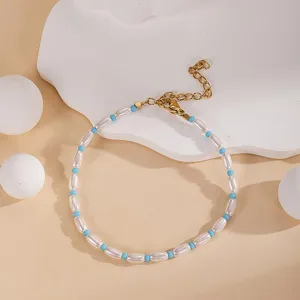 Details of the elegant beaded bracelet featuring white pearls and blue beads with gold clasp.