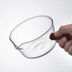 Borosilicate heat-resistant glass bowl with wooden handle, perfect for kitchen use.